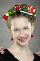portret van een grappig tiener- meisje met een krans van snoepgoed Aan haar hoofd. foto