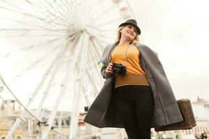 elegant vrouw poseren in de buurt ferris wiel foto