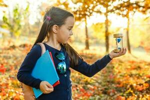 zandloper met herfst geel droog bladeren achtergrond foto