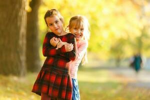 twee weinig meisjes in herfst park foto