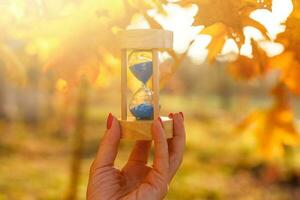 klok, zandlopers en herfst bladeren foto