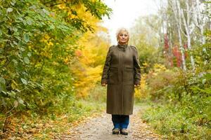 senior inwoner wandeling in een park in herfst foto