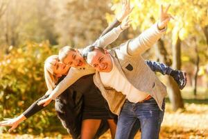 familie spelen in herfst park hebben pret foto