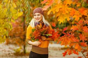 mode vrouw in herfst park Holding geel blad foto