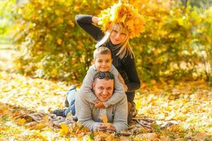 familie spelen in herfst park hebben pret foto