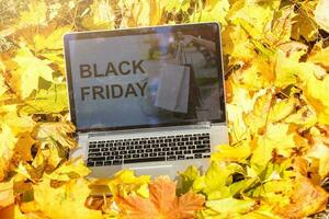 zwart vrijdag Aan laptop en herfst bladeren foto