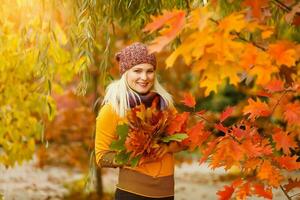 portret van vrolijk jong vrouw met herfst doorbladert in voorkant van gebladerte maken selfie foto