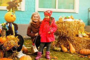 schattig weinig meisje met mam in een pompoen lapje, herfst eerlijk foto