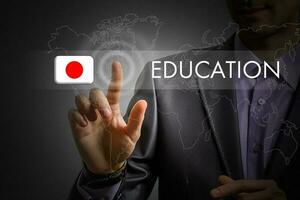 Japan onderwijs concept. Mens drukken virtueel knop met vlag icoon foto