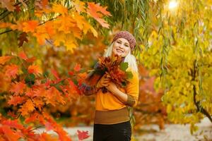 mode vrouw in herfst park Holding geel blad foto