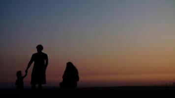 portret van familie op strand bij zonsondergang foto