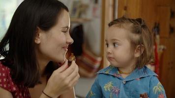 portret van moeder die snack eet met dochter foto