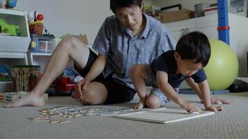 vader en jonge zoon doen puzzel thuis foto