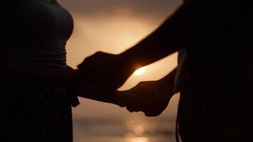 portret van een jong koppel hand in hand op het strand foto