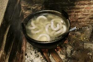 Koken wit bloed worst, in een ijzer pan, Aan een fornuis. foto