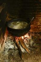 Koken wit bloed worst, in een ijzer pan, Aan een fornuis. foto