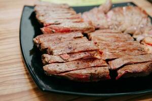 rundvlees steak met Groenen Aan een zwart bord. steak met basilicum gekookt in de culinaire meester klasse foto