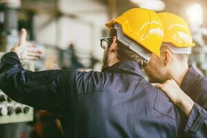 ingenieur arbeider werken samen opleiding technisch geven onderwijs oplossen machine probleem in fabriek werkplek. foto