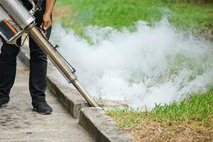 plaag controle personeel verstuiven chemisch rook elimineren mug larven ratten kakkerlak bugs in afvoeren grond buitenshuis. foto