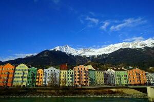 mooi kleurrijk gebouwen met besneeuwd bergen achter in innsbruck. foto