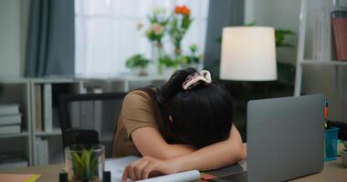 moe jong Aziatisch vrouw werken met een laptop Aan een bureau foto