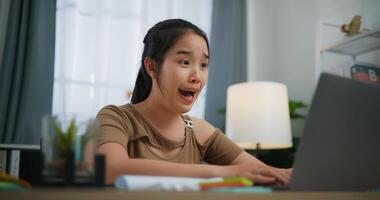 vrolijk jong Aziatisch vrouw werken met een laptop Aan een bureau foto