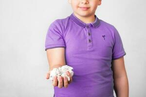 schattig jongen Holding papier bak vol van verfrommeld papieren verrast met een idee. bevorderen recycling van gebruikt papier foto