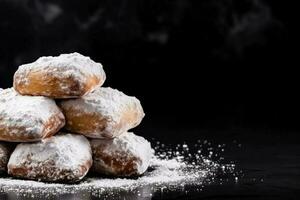 heerlijk beignets donker achtergrond met leeg ruimte voor tekst foto