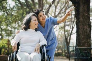 jong Aziatisch fysiek therapeut werken met senior vrouw Aan wandelen met een wandelaar foto