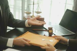 zaken en advocaten bespreken contractpapieren met koperen schaal op bureau in kantoor. wet, juridische diensten, advies, rechtvaardigheid en wet concept foto met film grain effect