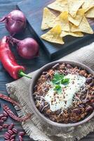 kom van Chili con carne met tortilla chips foto