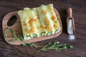 cannelloni met Ricotta en spinazie Aan de houten bord foto