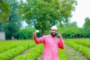 Indisch boer Holding gullak in hand, besparing concept, gelukkig arm boer foto