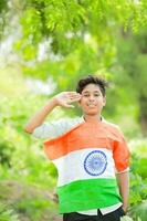 Indisch jongen Holding nationaal vlag in boerderij, gelukkig jongen, nationaal vlag foto