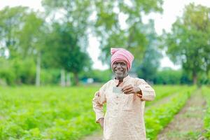 Indisch boer Holding gullak in hand, besparing concept, gelukkig arm boer foto