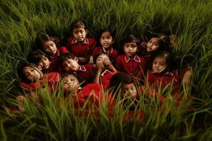 een groep van weinig kinderen zittend in de gras foto