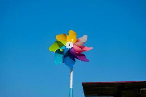 kleurrijk windmolens tegen een blauw lucht backdrop foto