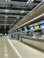 vallen van de avond visie van de Check in tellers Bij suvarnabhumi luchthavens terminal in Bangkok, Thailand, Aan juli 7, 2023. foto