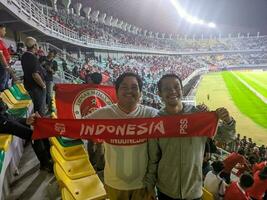 soera, Indonesië - 22 juni 2023 - Indonesisch Amerikaans voetbal team supporters Holding sjaals Bij de Indonesië vs Palestina bij elkaar passen Bij de stop tomo stadion foto