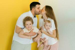 jong oprecht familie, waar een gelukkig vader en moeder houden hun baby zoon in hun armen en kus foto
