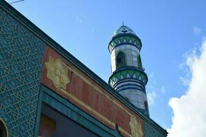 sier- minaret of toren van de moskee tegen blauw lucht foto