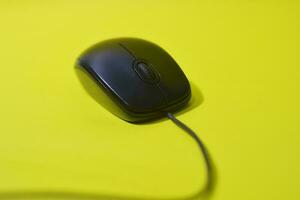 zwart computer muis geïsoleerd Aan geel achtergrond foto