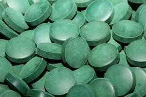 groen ronde gezond pillen macro medisch spirulina platensis ruimte voedsel modern hoog kwaliteit ogenblik prints tablets achtergrond top visie vitamine pillen dieet supplement alternatief geneeskunde foto