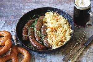 Beierse worstjes in een pan met gestoofde zuurkool oktoberfest food foto