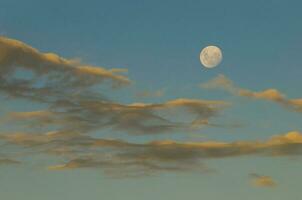 een vol maan is gezien in de lucht bovenstaand wolken foto