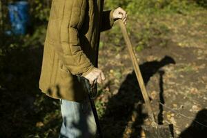 oud Mens in tuin. oud kleren Aan ouderen Mens. details van werk in landelijk gebieden. foto