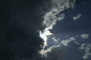 zon achter wolk. bewolkt het weer. stralen van licht door wolken. foto
