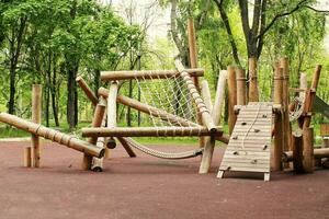houten speelplaats gemaakt van natuurlijk milieuvriendelijk materiaal in openbaar stad park. modern veiligheid kinderen buitenshuis apparatuur. concept van duurzame levensstijl en ecologie. kinderen rust uit en spellen Aan Open lucht foto