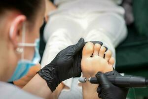 pellen pedicure procedure Aan de zool van eelt van de vrouw voet door een pedicure Bij een schoonheid salon. foto