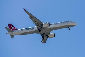 Turks luchtvaartmaatschappijen met vliegtuig luchtbus a321 naderen naar land- Bij Lissabon Internationale luchthaven tegen blauw lucht foto